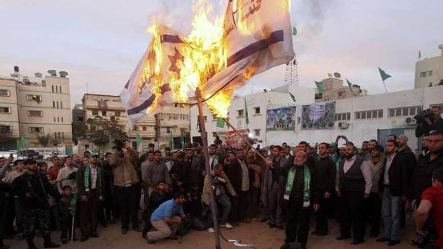 Senior Hamas leader Mahmoud al-Zahar burns Israeli flags in Gaza city in preparation for the movement's 23rd anniversary next week December 9, 2010. REUTERS/Mohammed Salem (GAZA - Tags: POLITICS ANNIVERSARY CIVIL UNREST) - RTXVKMR