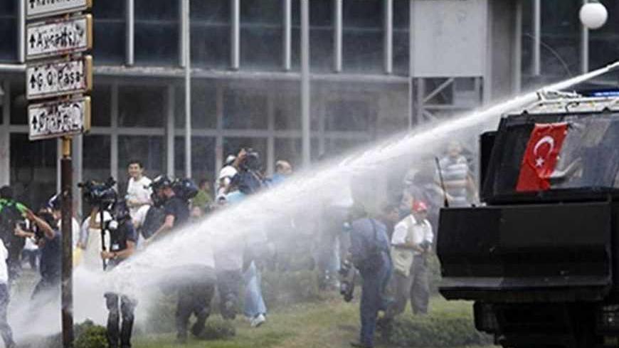 Members of the media are fired upon by a water cannon during protests at Kizilay square in central Ankara, June 16, 2013. The unrest, in which police fired teargas and water cannons at stone-throwing protesters night after night in cities including Istanbul and Ankara, left four people dead and about 5,000 injured, according to the Turkish Medical Association. REUTERS/Dado Ruvic (TURKEY - Tags: POLITICS CIVIL UNREST MEDIA) - RTX10Q1Q