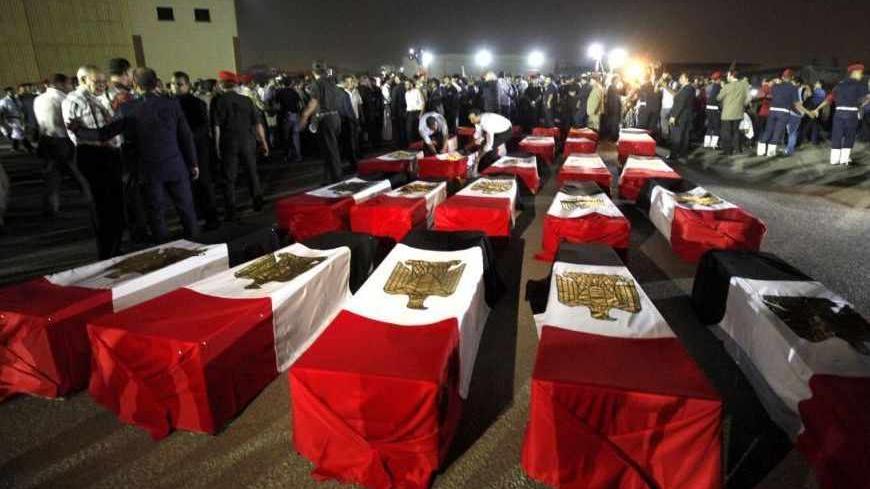 The caskets of 25 policemen killed early Monday morning near the north Sinai town of Rafah lay on the ground after arriving at Almaza military airport in Cairo August 19, 2013. The 25 Egyptian policemen were killed and three others wounded in an ambush by Islamist militants, medical and security sources said. Attacks by Islamist militants in the lawless north Sinai region have intensified since the army overthrew Islamist President Mohamed Mursi on July 3. REUTERS/Mohamed Abd El Ghany (EGYPT  - Tags: POLITI