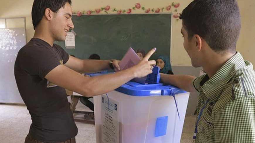 A youth casts his vote into a ballot box during the Iraq's provincial elections at a polling station in Ramadi, 100 km (62 miles) west of Baghdad, June 20, 2013. REUTERS/Ali al-Mashhadani (IRAQ - Tags - Tags: ELECTIONS POLITICS) - RTX10ULM