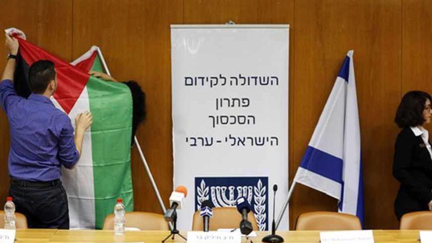 Israeli parliament employees set up a Palestinian flag (L) next to an Israeli one as they prepare ahead of a meeting between Israeli parliament members and a delegation of Palestinian politicians and businessmen, aimed at encouraging Israeli-Palestinian negotiations, at the Knesset, the Israeli parliament, in Jerusalem July 31, 2013. Israeli and Palestinian negotiators on Tuesday gave themselves about nine months to try reach an agreement on ending their conflict of more than six decades in U.S.-brokered pe