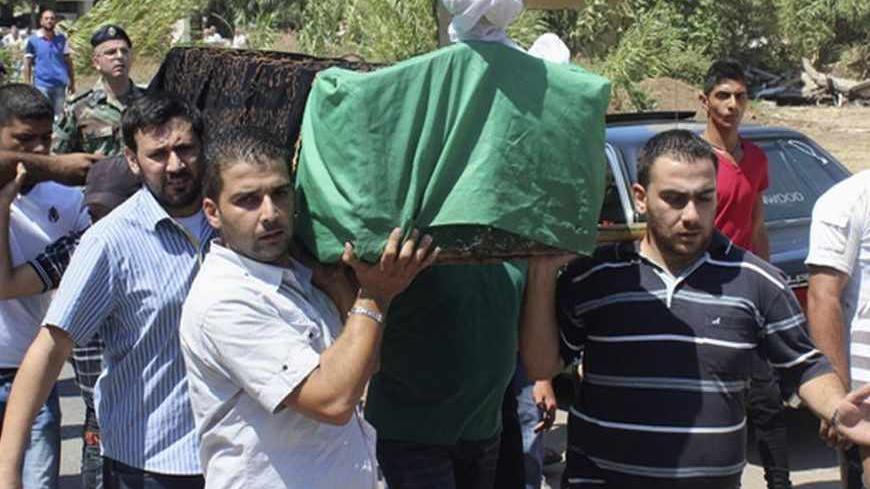 Relatives carry the coffin of a female victim who died yesterday from the bombs blasts that hit two mosques in the northern Lebanese city of Tripoli August 24, 2013. Bombs hit two mosques in the northern Lebanese city of Tripoli on Friday, killing at least 42 people and wounding hundreds, intensifying sectarian strife that has spilled over from the civil war in neighbouring Syria. REUTERS/Rayan al-Turk (LEBANON - Tags: POLITICS CIVIL UNREST) - RTX12V6Z