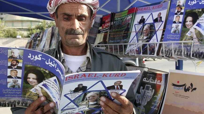A man reads a copy of the magazine "Israel-Kurd" at a street in Arbil, 310 km (190 miles) north of Baghdad August 16, 2009. REUTERS/Azad Lashkari (IRAQ SOCIETY) - RTR26SCA