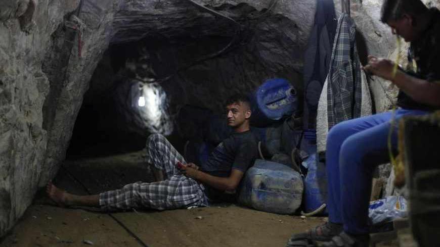 Palestinian tunnel workers rest inside a smuggling tunnel dug beneath the Gaza-Egypt border in the southern Gaza Strip July 19, 2013. Palestinians in the Gaza Strip are reeling from another devastating blockade but this time they are blaming Egypt, the neighbouring Arab power they once hoped would end their isolation, rather than their old foe Israel. Picture taken July 19, 2013. REUTERS/Ibraheem Abu Mustafa (GAZA - Tags: POLITICS) - RTX11TRO