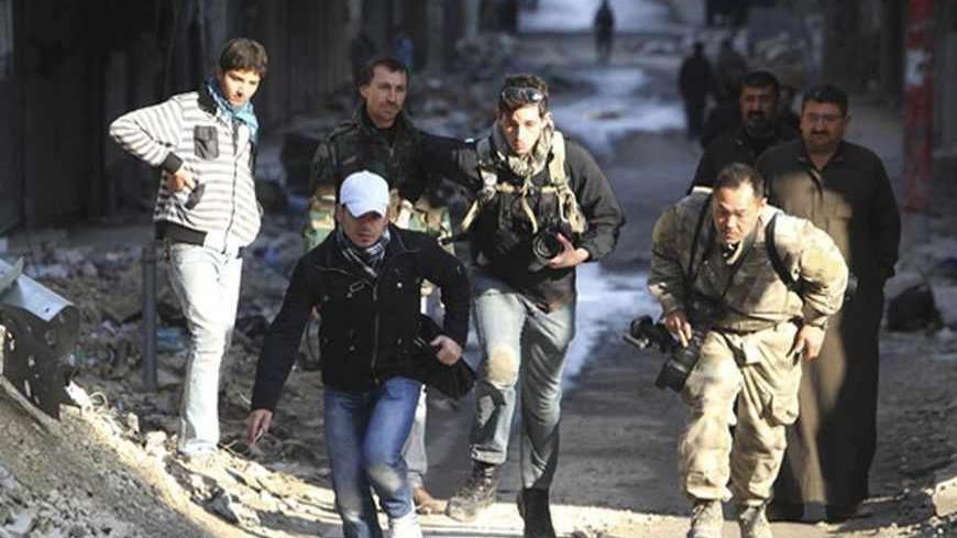 Journalists Bryn Karcha (C) of Canada and Toshifumi Fujimoto (R) of Japan run for cover next to an unidentified fixer in a street in Aleppo's district of Salaheddine December 29, 2012. REUTERS/Muzaffar Salman    (SYRIA - Tags: CONFLICT MEDIA) - RTR3BZ0P