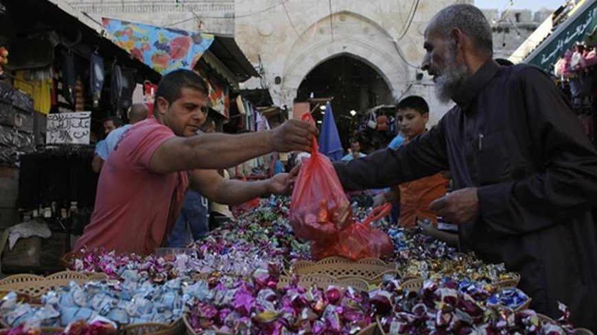 Palestinians buy sweets in Jerusalem's Old City ahead of the Muslim holiday of Eid al-Fitr, which marks the end of the holy month of Ramadan, August 7, 2013. REUTERS/Ammar Awad (JERUSALEM - Tags: RELIGION FOOD) - RTX12D0X