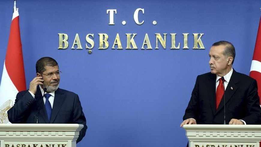 Turkey's Prime Minister Tayyip Erdogan (R) and Egypt's President Mohamed Mursi attend a news conference in Ankara September 30, 2012. Picture taken September 30, 2012. REUTERS/Yasin Bulbul/Prime Minister's Press Office/Handout (TURKEY - Tags: POLITICS) FOR EDITORIAL USE ONLY. NOT FOR SALE FOR MARKETING OR ADVERTISING CAMPAIGNS. THIS IMAGE HAS BEEN SUPPLIED BY A THIRD PARTY. IT IS DISTRIBUTED, EXACTLY AS RECEIVED BY REUTERS, AS A SERVICE TO CLIENTS - RTR38N60