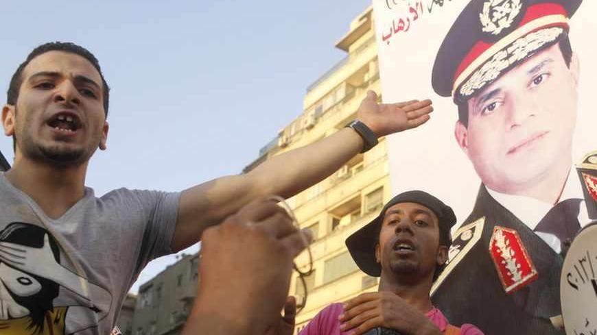 Protesters cheer with drums near a poster of army chief Abdel-Fattah El-Sisi as they gather for a mass protest to support the army in Tahrir square in Cairo July 26, 2013. Ousted Egyptian president Mohamed Mursi is under investigation for an array of charges including murder, the state news agency said on Friday, stoking tensions as opposing political camps took to the streets. Confirming the potential for bloodshed, two men were killed in confrontations in Alexandria and a further 19 were hurt, Mena news a
