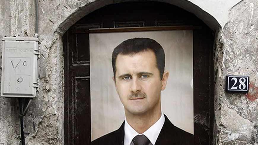 A portrait of Syria's President Bashar al-Assad is affixed on a door in old Damascus, September 8, 2013. REUTERS/Khaled al-Hariri  (SYRIA - Tags: POLITICS CONFLICT CIVIL UNREST) - RTX13D2N
