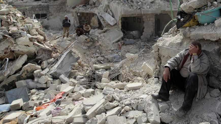 A man reacts as he sits in rubble at a site hit on Friday by what activists said was a Scud missile in Aleppo's Ard al-Hamra neighbourhood, February 23, 2013. Rockets struck eastern districts of Aleppo, Syria's biggest city, on Friday, killing at least 29 people and trapping a family of 10 in the ruins of their home, activists in the city said. REUTERS/Muzaffar Salman (SYRIA - Tags: POLITICS CIVIL UNREST) - RTR3E62Q