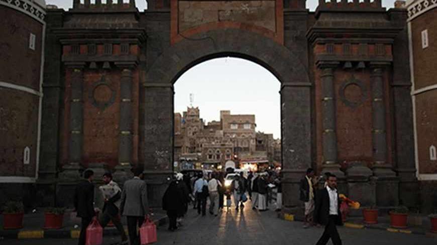 People walk past the Bab al-Yemen gate of the Old Sanaa city January 6, 2013. REUTERS/Khaled Abdullah (YEMEN - Tags: SOCIETY CITYSCAPE) - RTR3C5QS