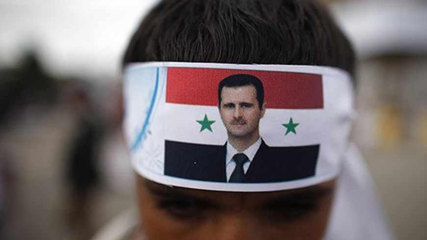 A protester loyal to the Shi'ite Muslim Al-Houthi group, also known as Ansarullah, wears a headband with a picture of Syria's President Bashar al-Assad as he attends a demonstration against potential strikes on the Syrian government, in Sanaa September 6, 2013. REUTERS/Khaled Abdullah (YEMEN - Tags: POLITICS CIVIL UNREST) - RTX139T8