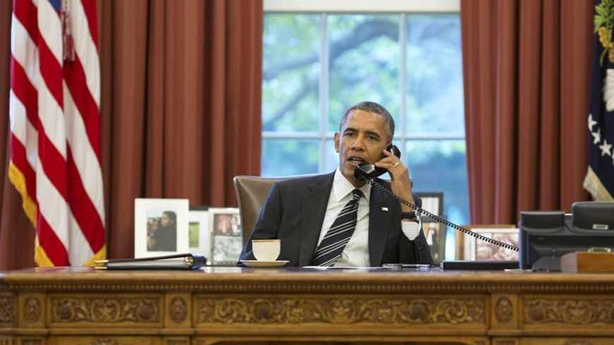 U.S. President Barack Obama talks with Iranian President Hassan Rouhani during a phone call in the Oval Office at the White House in Washington September 27, 2013. U.S. President Barack Obama and new Iranian President Hassan Rouhani held the historic phone call on Friday, in the highest level conversation between the estranged nations in more than three decades. Speaking to reporters at the White House, Obama said both men had directed their teams to work expeditiously toward an agreement on Iran's nuclear 