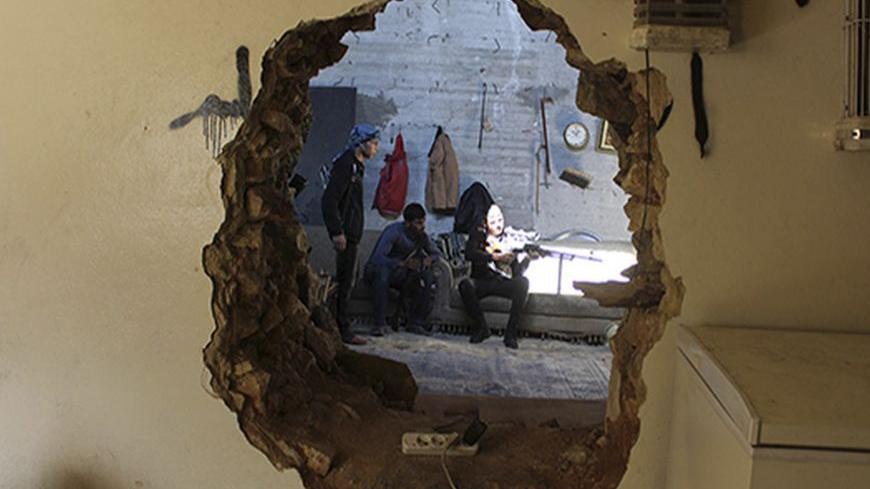 A Free Syrian Army fighter aims his weapon as he is seen through a hole in a wall in Aleppo's Karm al-Jabal district October 21, 2013. REUTERS/Molhem Barakat (SYRIA - Tags: POLITICS CIVIL UNREST CONFLICT) - RTX14IU3