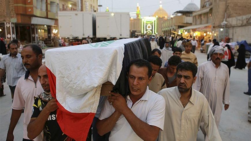 Relatives carry the coffin of an Iraqi police officer killed by militants during a funeral in Najaf, around 160 km (99 miles)
 south of Baghdad May 20, 2013. The attacks took place in the Sunni heartland of Anbar, where gunmen on Saturday ambushed and kidnapped 10 policemen near the provincial capital of Ramadi, and four members of a government-backed Sunni militia fighters were killed near Falluja city When Sunni-Shi'ite bloodshed was at its height in 2006-07, Anbar, which shares a border with Syria, was i