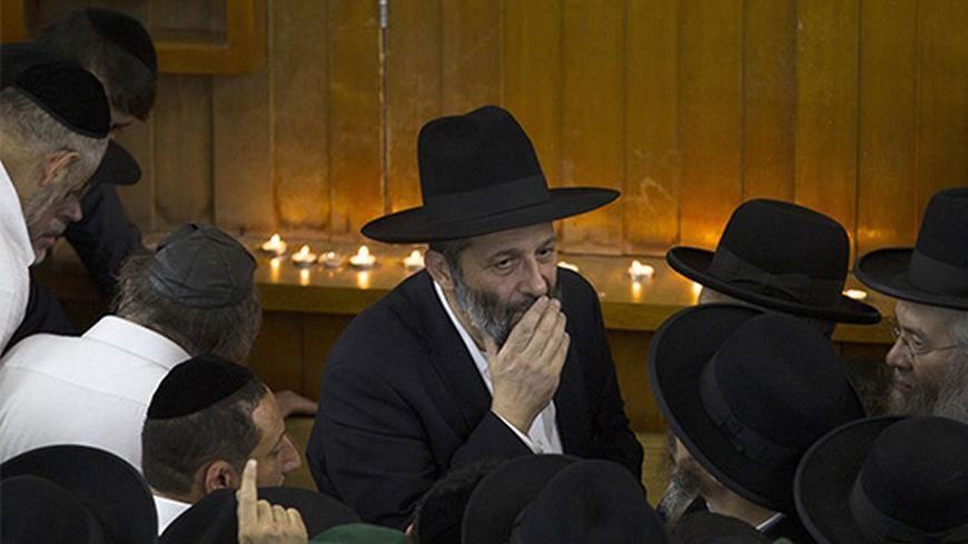 Aryeh Deri (C), leader of the ultra-religious Shas political party, looks on near the body of Rabbi Ovadia Yosef, the spiritual leader of Shas,  before his funeral at a seminary in Jerusalem October 7, 2013. Yosef, an Iraqi-born sage who turned an Israeli underclass of Sephardic Jews of Middle Eastern heritage into a powerful political force, died on Monday at the age of 93, plunging masses of followers into mourning. REUTERS/Ronen Zvulun (JERUSALEM - Tags: POLITICS RELIGION OBITUARY) - RTX142ZS