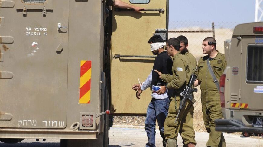Israeli soldiers detain a Palestinian close to the scene where Sariya Ofer, a retired Israeli army officer was killed in the West Bank Jewish settlement of Brosh Habika in the Jordan Valley October 11, 2013. Ofer was killed and his wife injured in what appeared to be an attack by Palestinian militants in the occupied West Bank, Israeli officials said on Friday. Israeli government ministers branded it a terror attack and some urged Prime Minister Benjamin Netanyahu to pull out of peace talks with the Palesti