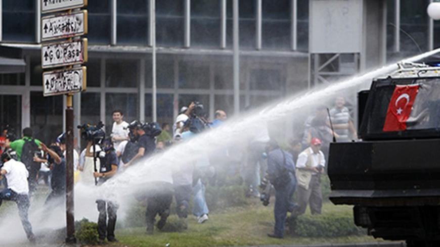 Members of the media are fired upon by a water cannon during protests at Kizilay square in central Ankara, June 16, 2013. The unrest, in which police fired teargas and water cannons at stone-throwing protesters night after night in cities including Istanbul and Ankara, left four people dead and about 5,000 injured, according to the Turkish Medical Association. REUTERS/Dado Ruvic (TURKEY - Tags: POLITICS CIVIL UNREST MEDIA) - RTX10Q1Q