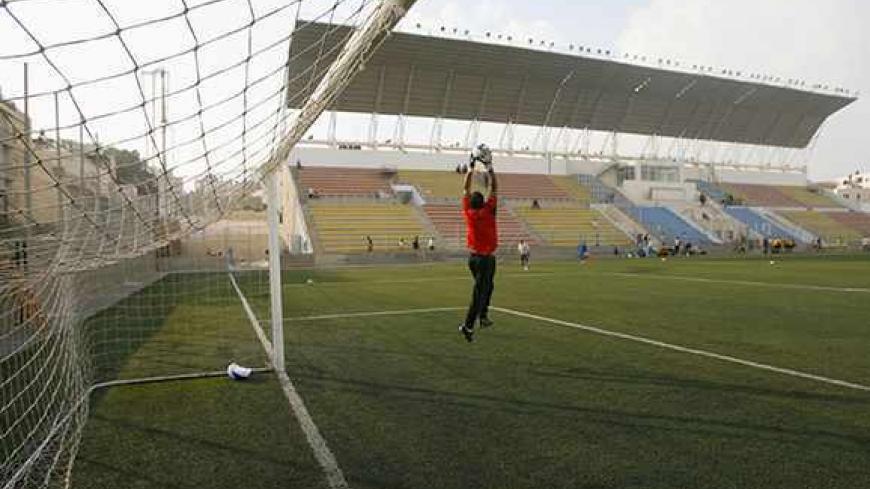 A Palestinian national team goalkeeper catches the ball during a warm-up before a local friendly soccer match at a stadium in al-Ram, on the edge of Jerusalem October 22, 2008. The Palestinian national team will play its first match on home soil on Sunday when they host Jordan in an international friendly at a new stadium near Jerusalem, the Palestinian FA chairman Jibril Rajoub said. Picture taken October 22, 2008. REUTERS/Fadi Arouri (JERUSALEM) - RTX9UN9