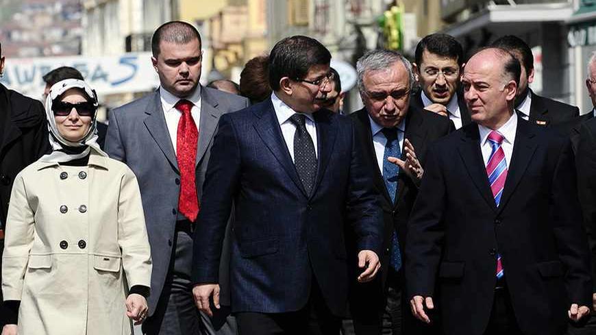Turkey's Foreign Minister Ahmet Davutoglu (C) and his wife Sare Davutoglu (L) walk with mayor Vladimir Talevski (R) in the centre of Bitola March 25, 2010. Davutoglu is on a two-day official visit to Macedonia. REUTERS/Ognen Teofilovski (MACEDONIA - Tags: POLITICS) - RTR2C263