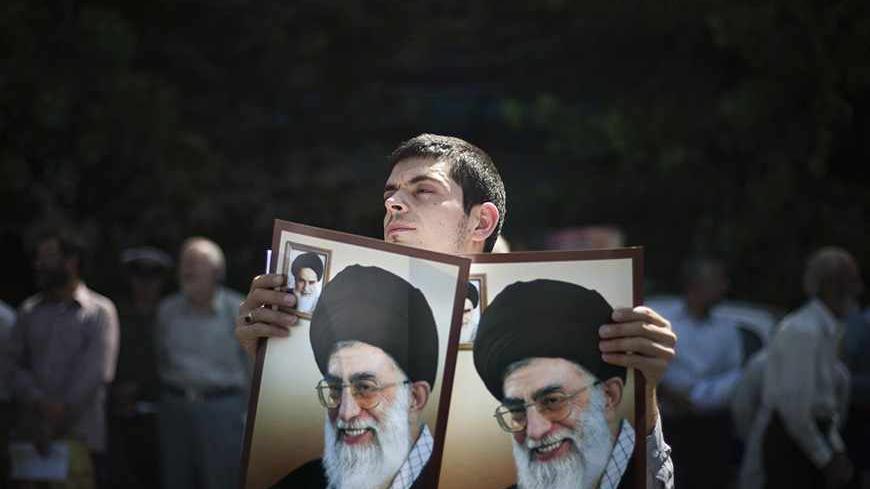 EDITORS' NOTE: Reuters and other foreign media are subject to Iranian restrictions on their ability to film or take pictures in Tehran.

An Iranian worshipper holds portraits of Iran's Supreme Leader Ayatollah Ali Khamenei while attending a demonstration to support the people of Bahrain after Friday prayers in Tehran September 9, 2011. REUTERS/Morteza Nikoubazl (IRAN - Tags: POLITICS CIVIL UNREST RELIGION TPX IMAGES OF THE DAY) - RTR2R0B3