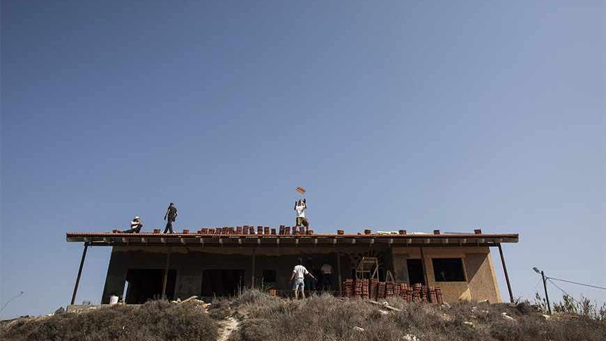 Men work on the roof of a house under construction in the unauthorised Jewish settler outpost of Havat Gilad, south of the West Bank city of Nablus November 5, 2013. Israeli and Palestinian officials said on Tuesday the three-month-old peace talks pressed on them by Washington are going nowhere, painting a grim picture for a visit this week by U.S. Secretary of State John Kerry. Both sides have been airing their frustration over a lack of progress in the U.S.-brokered talks aimed at resolving core issues su