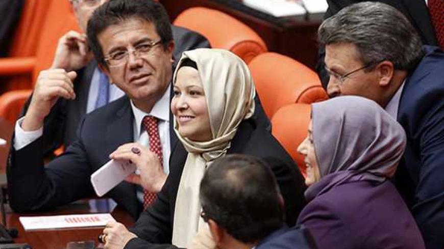 Turkey's ruling Ak Party (AKP) lawmakers Nurcan Dalbudak (C) and Sevde Beyazit Kacar (R) attend the general assembly wearing their head scarves at the Turkish Parliament in Ankara October 31, 2013. Four female lawmakers from Turkey's Islamist-rooted ruling party wore their Islamic head scarves in parliament on Thursday in a challenge to the country's secular tradition. The last time a lawmaker attempted to wear the head scarf in parliament in 1999 she was expelled from the assembly. REUTERS/Umit Bektas (TUR