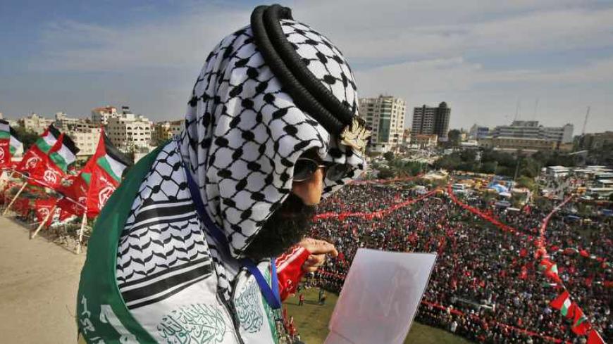 A Palestinian watches a rally marking the 46th anniversary of the founding of the Popular Front for the Liberation of Palestine (PFLP), in Gaza City December 7, 2013. REUTERS/Suhaib Salem (GAZA - Tags: POLITICS CIVIL UNREST ANNIVERSARY) - RTX1681X