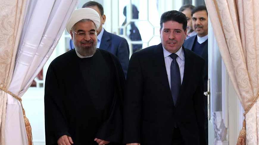 Iranian President Hassan Rouhani (L) welcomes Syrian Prime Minister Wael al-Halaqi ahead of a meeting in Tehran on December 1, 2013. AFP PHOTO/ATTA KENARE        (Photo credit should read ATTA KENARE/AFP/Getty Images)