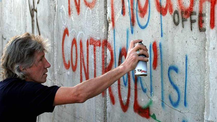 (FILES) Roger Waters, British rock legend and co founder of the group Pink Floyd, paints a graffiti at Israel’s separation barrier surrounding the West Bank town of Bethlehem the day before his concert near Tel Aviv, 21 June 2006. The United Nations on August 19, 2009 premiered a film narrated by former Pink Floyd frontman Roger Waters on the plight of Palestinians living in the shadow of Israel's controversial separation barrier. The 15-minute film entitled "Walled Horizons" was made in honour of the fifth