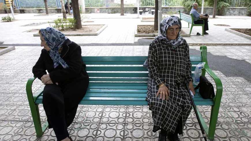 Women sit on a park bench in Tehran June 9, 2009. Iranians vote on Friday in the 10th presidential election since the 1979 Islamic revolution which toppled the U.S.-backed Shah. Three decades after the revolution, Reuters invited some older Iranians who witnessed the Shah's overthrow to look back at the changes they have lived through. To match feature IRAN-ELECTION/REVOLUTION             REUTERS/Raheb Homavandi (IRAN POLITICS ELECTIONS) - RTR24JM3