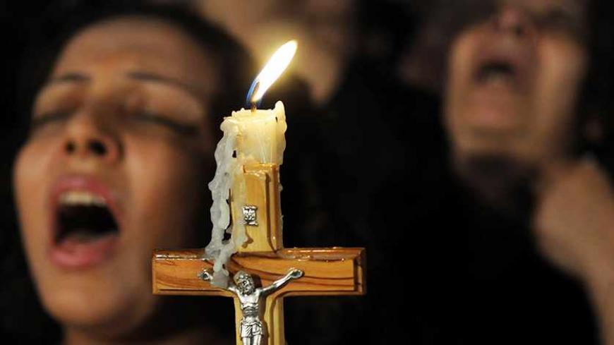 Egyptian Coptic Christians carry a cross and chant prayers during a candlelight protest marking one week since sectarian clashes with soldiers and riot police at a protest against an attack on a church in southern Egypt, at Abassaiya Cathedral in Cairo October 16, 2011. Egyptians detained in connection with clashes between Christian protesters and military police that left 25 people dead should be tried in civilian not military courts, presidential candidate Mohamed ElBaradei said on Sunday. REUTERS/Stringe