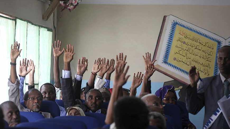 Members of the Somali parliament vote by a show of hands in Mogadishu December 2, 2013.  Somalia's parliament voted on Monday to sack Prime Minister Abdi Farah Shirdon, the speaker of parliament said, after a row with the president that has paralysed the state and threatened a shaky recovery from war. The prime minister, who was appointed last year, fell out with President Hassan Sheikh Mohamud over what legislators said was a dispute over the composition of a new cabinet, prompting Monday's no confidence v