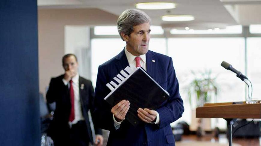 U.S. Secretary of State John Kerry picks up his notebook after answering questions from members of the media before his departure from Ben Gurion International Airport in Tel Aviv, December 6, 2013. REUTERS/Pablo Martinez Monsivais/Pool (ISRAEL - Tags: POLITICS) - RTX166GA