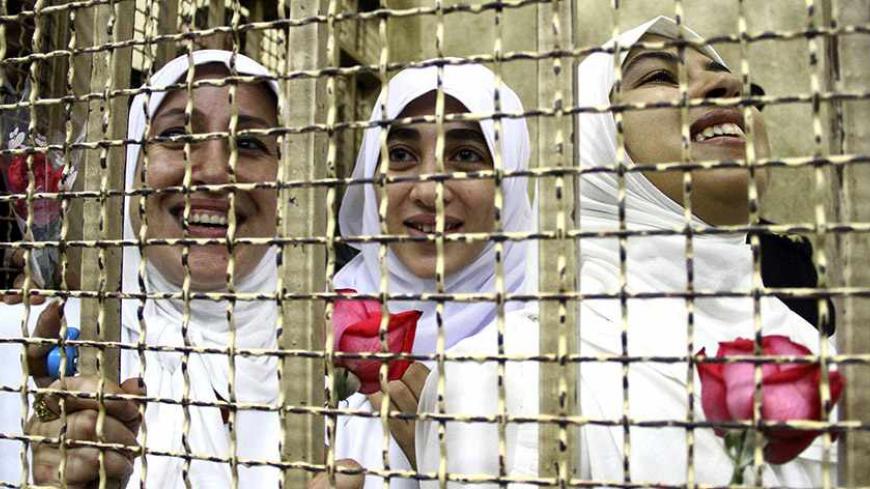 Women, who were found guilty of obstructing traffic during a pro-Islamist protest in October, smile during their appeal hearing at a court in the Mediterranean city of Alexandria, 230 km (143 miles) north of Cairo December 7, 2013. Last month, 14 women were imprisoned for 11 years, while seven teenage girls under the age of 18 were sent to juvenile prison.  REUTERS/Stringer (EGYPT - Tags: POLITICS CRIME LAW CIVIL UNREST) - RTX1685K