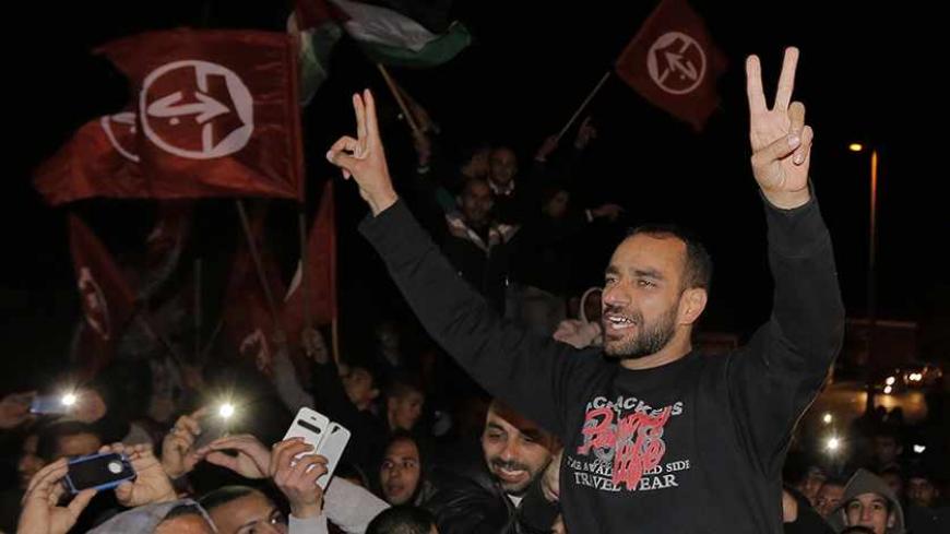 Released Palestinian prisoner Samer al-Issawi gestures as he celebrates in the East Jerusalem neighbourhood of Issawiya December 23, 2013. Israel on Monday freed al-Issawi from jail, to complete a deal agreed earlier this year over his release in exchange for him ending a lengthy hunger strike that almost killed him. REUTERS/Ammar Awad (JERUSALEM - Tags: POLITICS CIVIL UNREST) - RTX16SOH