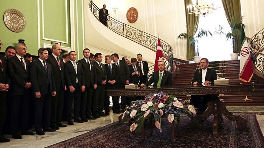 The Turkish delegation stand as Turkish Prime Minister Recep Tayyip Erdogan (C-L) and Iran's First Vice President Eshaq Jahangiri (R) speak to the media at Tehran's Saadabad palace on January 29, 2014. Erdogan's visit comes as the two countries are trying to rebuild relations strained by the situation in Syria, with Iran supporting President Bashar al-Assad while Turkey backs the rebels seeking to oust him. AFP PHOTO/BEHROUZ MEHRI        (Photo credit should read BEHROUZ MEHRI/AFP/Getty Images)