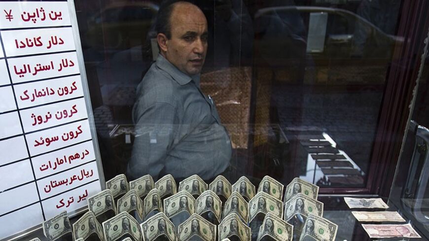 EDITORS' NOTE: Reuters and other foreign media are subject to Iranian restrictions on leaving the office to report, film or take pictures in Tehran.

An exchange currency dealer sits at his shop as he waits for customer in Tehran's business district October 24, 2011. Iranian media reported last week that monetary authorities had reversed a six-month-old decision to cut interest on bank deposits, aiming to mop up excess cash in the economy and halt a dangerous rise of inflation. The news made sense to econom