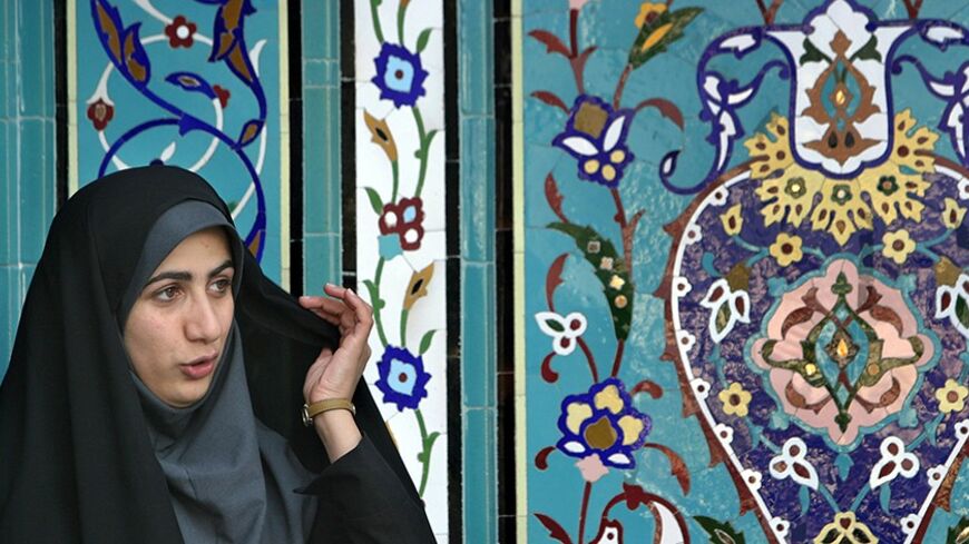 A young Iranian veiled woman stands in front of a mosque at the 18th Tehran International Book Fair May 8, 2005. Aspirants vying to replace outgoing reformist cleric Mohammad Khatami in the June 17 election must first be vetted by a constitutional watchdog known as the Guardian Council which comprises of six clerics and Islamic jurists who have in the past always rejected women hopefuls. REUTERS/Morteza Nikoubazl  MN/YH - RTRAIQA