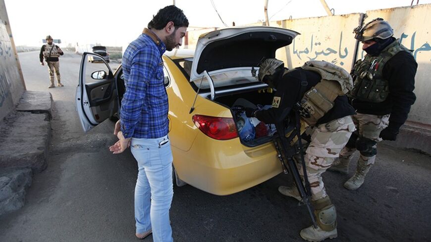 Iraqi soldiers inspect a vehicle at a check point in west Baghdad, January 6, 2014.  Iraq's prime minister urged people in the besieged city of Falluja on Monday to drive out al Qaeda-linked insurgents to pre-empt a military offensive that officials said could be launched within days. In a statement on state television, Nuri al-Maliki, a Shi'ite Muslim whose government has little support in Sunni-dominated Falluja, called on tribal leaders to drive out militants who last week seized key towns in the desert 