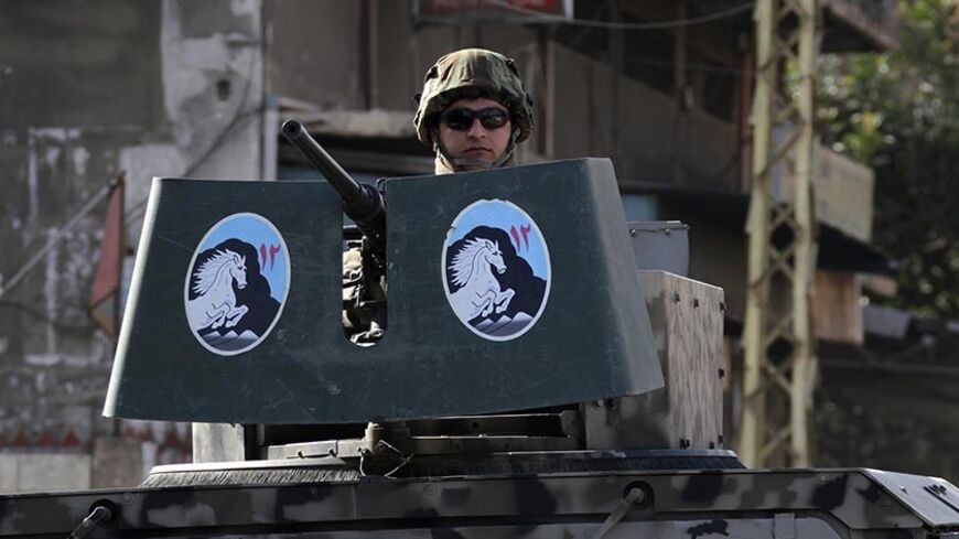 A Lebanese army soldier is seen on a military vehicle while patrolling a street in the Sunni Muslim Bab al-Tebbaneh neighbourhood in Tripoli, northern Lebanon, January 21, 2014. Seven people, including a three-year-old boy, have been killed since Saturday in Tripoli, medical and security sources said. The victims are the latest casualties of violence fuelled by sectarian tensions over neighbouring Syria's civil war. REUTERS/Omar Ibrahim (LEBANON - Tags: POLITICS CIVIL UNREST MILITARY) - RTX17O15