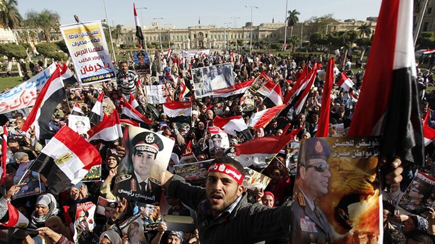 Supporters of Egypt's army chief General Abdel Fattah al-Sisi hold posters of Sisi and wave flags in front of Abdeen Presidential Palace in downtown Cairo, January 24, 2014. A wave of bomb attacks targeting police hit Cairo on Friday, killing six people on the eve of the third anniversary of the uprising that toppled autocrat Hosni Mubarak and raising fears that an Islamist insurgency is gaining pace in Egypt. REUTERS/Mohamed Abd El Ghany (EGYPT - Tags: POLITICS CIVIL UNREST CRIME LAW) - RTX17T0A