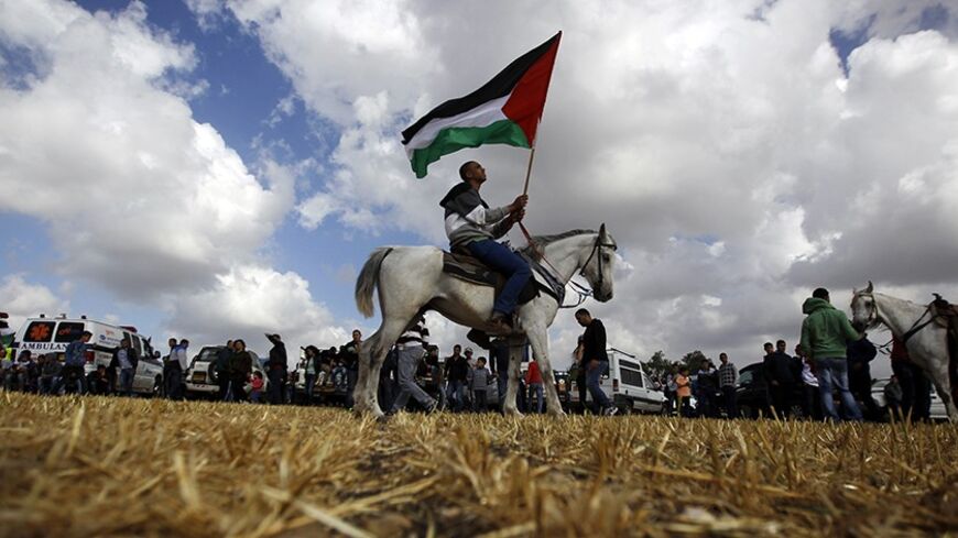 An Arab-Israeli protester on a horse holds a Palestinian flag during a march in support of the right of return for Palestinian refugees who fled their homes or were expelled during the 1948 war that followed the creation of the state of Israel, near the Arab-Israeli town of Umm al-Fahm April 16, 2013.      REUTERS/Ammar Awad (ISRAEL - Tags: CIVIL UNREST ANIMALS POLITICS TPX IMAGES OF THE DAY) - RTXYO2G