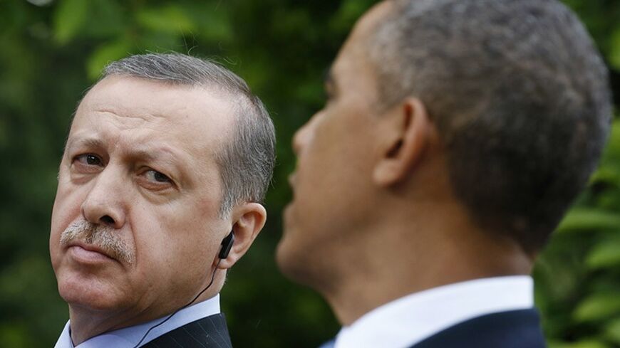 Turkish Prime Minister Recep Tayyip Erdogan (L) listens as U.S. President Barack Obama (R) addresses a joint news conference in the White House Rose Garden in Washington, May 16, 2013.   REUTERS/Kevin Lamarque (UNITED STATES  - Tags: POLITICS)   - RTXZPBL