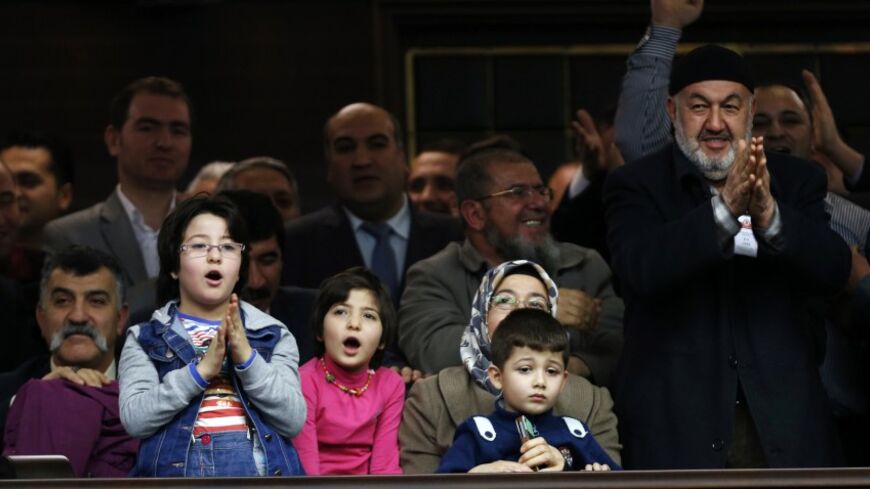 Supporters of Turkey's Prime Minister Tayyip Erdogan react as he addresses the audience during a meeting at the Turkish parliament in Ankara January 28, 2014. Erdogan, keen to maintain economic growth ahead of an election cycle starting in two months, has been a vociferous opponent of the higher borrowing costs sometimes needed to bolster currencies, railing against what he describes as an 'interest rate lobby' of speculators seeking to stifle growth and undermine the economy. REUTERS/Umit Bektas (TURKEY - 