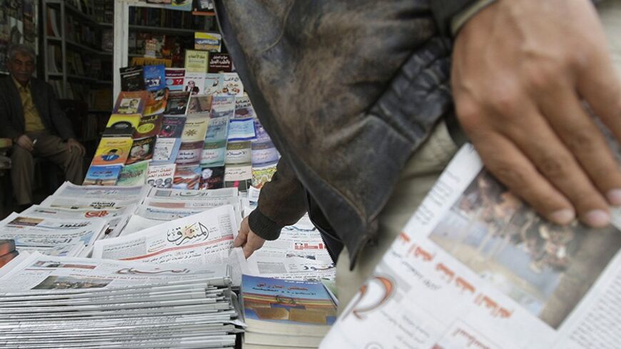 A resident buys newspapers from a kiosk in Baghdad February 23, 2009. A boom in local media since the U.S.-led invasion in 2003 has given Iraqis a choice between some 200 print outlets, 60 radio stations and 30 TV channels in Arabic, Turkmen, Syriac and two Kurdish dialects. Yet most media outlets remain dominated by sectarian and party patrons who use them for their own ends, and have yet to become commercially sustainable enterprises let alone watchdogs keeping government under scrutiny, the favoured West