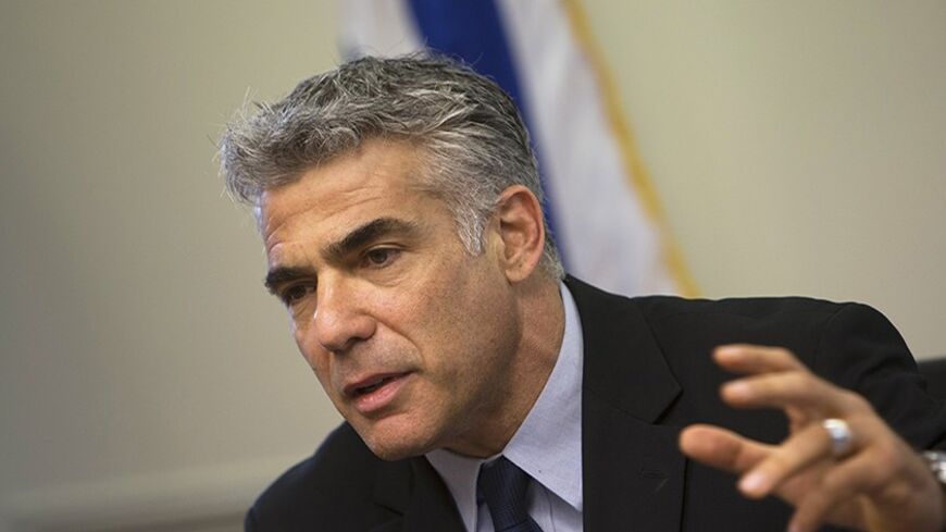 Israel's Finance Minister Yair Lapid gestures as he speaks during a Yesh Atid party meeting at the Knesset, the Israeli parliament, in Jerusalem May 20, 2013. Lapid, whose new centrist party is the second largest in Israel's government, said on Monday thousands of Jewish settlers would have to be removed from occupied land under any peace deal with the Palestinians. REUTERS/Ronen Zvulun (JERUSALEM - Tags: POLITICS) - RTXZTWQ