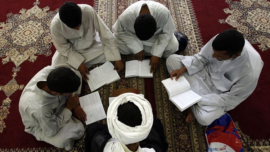 An Iraqi Shiite scholar (C) lectures his students during a lesson at a religious school for clerics, known in Arabic as Haouza, in the holy city of Najaf, 160 kms (100 miles) south of Baghdad, 05 August 2006. The teaching method at the clerical school in Najaf has not radically changed since its establishment in 1056 AD, with the exception of adding natural sciences subjects to the curriculum.  AFP PHOTO/ALI AL-SAADI (Photo credit should read ALI AL-SAADI/AFP/Getty Images)
