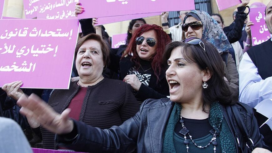 A woman shouts slogans as others hold banners during a sit-in in front of Beirut's national museum, marking International Women's Day, March 8, 2012. Lebanese women held a sit-in, demanding to stop discrimination and violence against women in Lebanon, and asking for equality and citizenship rights for the children of Lebanese women married to foreign men. REUTERS/Mohamed Azakir   (LEBANON - Tags: ANNIVERSARY CIVIL UNREST POLITICS) - RTR2Z180