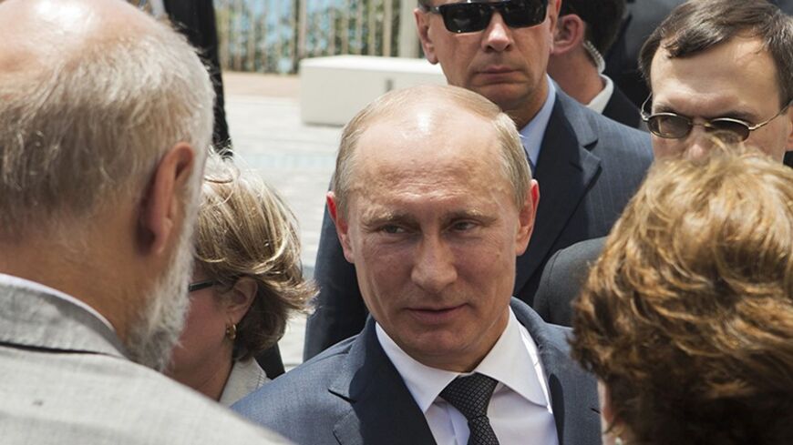 Russian President Vladimir Putin (C) is greeted during an unveiling ceremony for a monument commemorating the victory of the Soviet Red Army in World War Two in the coastal city of Netanya, north of Tel Aviv June 25, 2012. Israeli President Shimon Peres on Monday urged visiting Putin to take steps to avert the threat of a nuclear-armed Iran and to stop the bloodshed in Syria. REUTERS/Jack Guez/Pool (ISRAEL - Tags: POLITICS) - RTR344SB